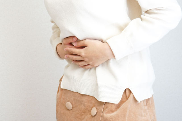お腹を抑える女性